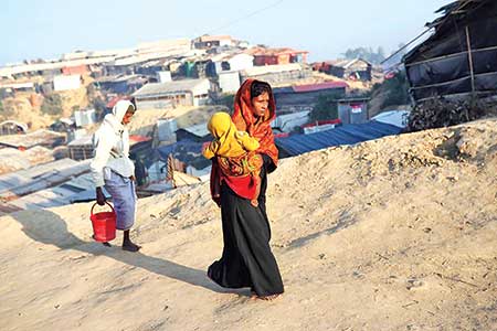 Rohingya refugees walk at Jamtoli camp in the morning in Cox's Bazar on Monday.	PHOTO : Reuters