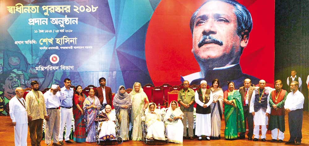 Prime Minister Sheikh Hasina poses for a photo session with the recipients of 'Swadhinata Puraskar-2018' at Osmani Memorial Auditorium in the city on Sunday. photo : pid