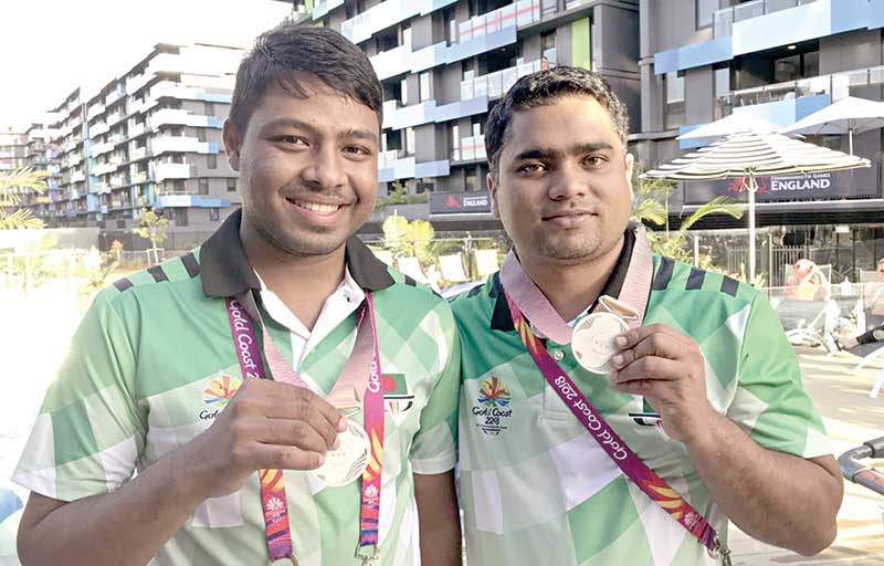 Shooter Shakil Ahmed (L) and Abdullah Hel Baki showing their medal after Shakil wins the 50m Air pistol event of the ongoing Commonwealth Games at Belmont Shooting Centre in Brisbane, Australia on Wednesday.	photo: Boa