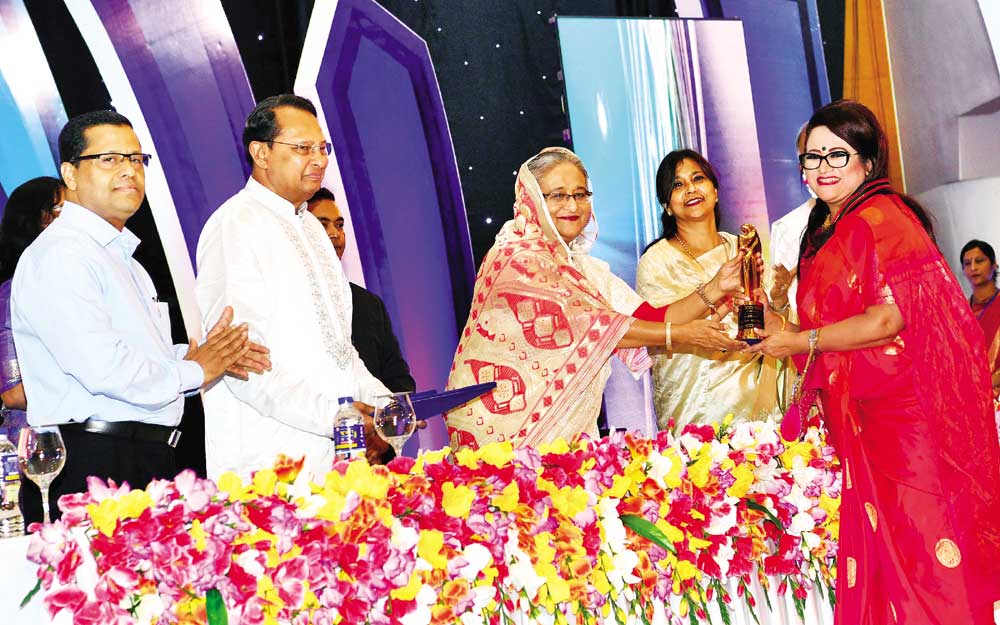 Prime Minister Sheikh Hasina handing over lifetime achievement award to renowned film actress Farida Akter Babita while distributing National Film Award-2016 at a gala ceremony at Bangabandhu International Conference Centre in the capital on Sunday. 	 photo: pid