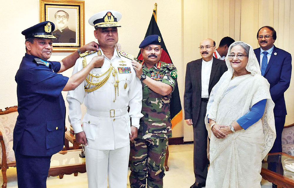 Chief of Army Staff General Aziz Ahmed and Chief of Air Staff Air Chief Marshal Masihuzzaman Serniabat adorn New Chief of Naval Staff AMMM Aurangzeb Chowdhury with the rank badge of Admiral in presence of Prime Minister Sheikh Hasina on Sunday.	photo : pid