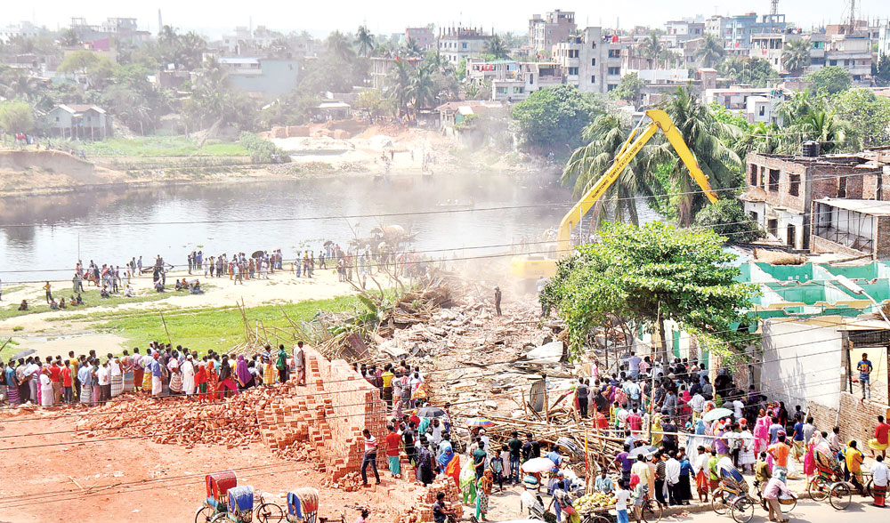 A BIWTA excavator razes to the ground a multistoried building erected illegally on the bank of the Turag River at Diabari of Mirpur on the outskirts of the capital on Thursday as part of drive against illegal structures.	photo: Observer