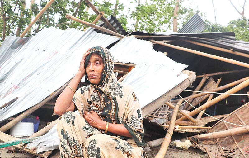 a woman wailing beside her damaged house at Char Chandia Village in Sonagazi Upazila of Feni