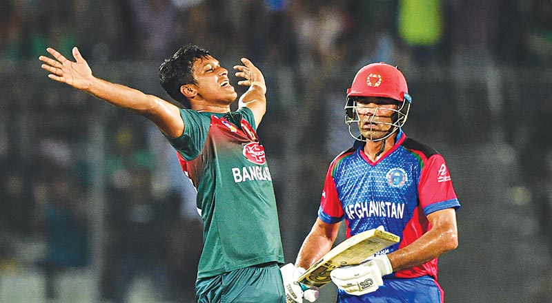 Bangladesh's Mohammad Saifuddin (L) reacts after the dismissal of Afghanistan's Najeeb Tarakai (R) during the third match between Afghanistan and Bangladesh in the T20 Tri-nations cricket series at the Sher-e-Bangla National Stadium in Dhaka on September 14, 2019. 	photo: AFP 