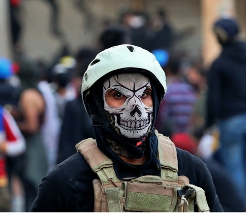 A protester wears a mask during clashes with security forces, in Baghdad, Iraq, Sunday, Nov. 24, 2019 --AP