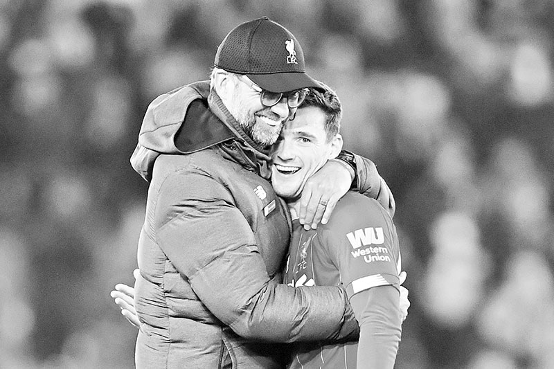 Liverpool's German manager Jurgen Klopp (L) embraces Liverpool's Scottish defender Andrew Robertson (R) at the end of the English Premier League football match between Liverpool and Wolverhampton Wanderers at Anfield in Liverpool, north west England, on December 29, 2019. photo: AFP
