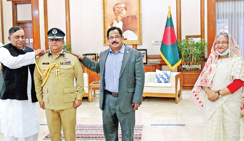 Home Minister Asaduzzaman Khan and Senior Secretary of the Ministry of Home Affairs Mustafa Kamal Uddin adorning the Rank Badge to the new IGP, Benazir Ahmed, in presence of Prime Minister Sheikh Hasina at Ganobhaban on Wednesday.	photo : BSS