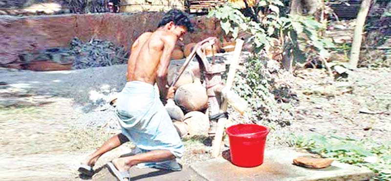 The photo shows a man trying to collect water from a tube-well in Rajshahi.
