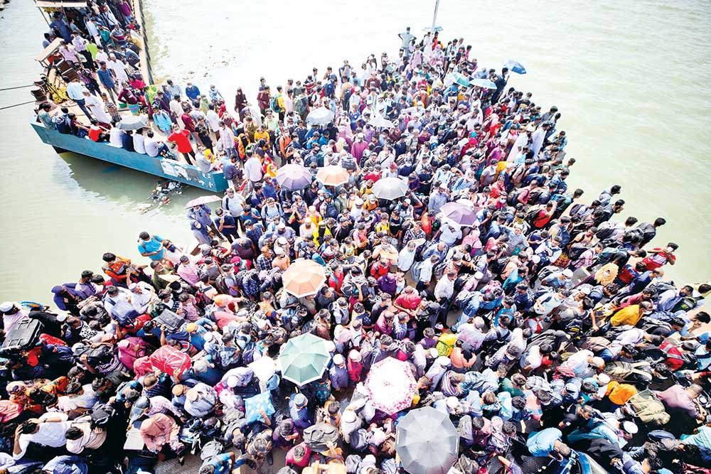 DARE DEVILS BRAVING LOCKDOWN: Thousands of homebound passengers pack the platform of Shimulia Ferry Ghat like sardines in a tin can on Monday waiting for the ferry to arrive to take them to the other side of Padma River on their onward journey to their destinations.	PHOTO: OBSERVER