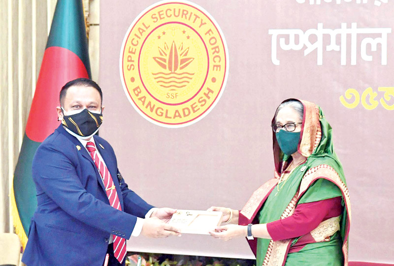 Maj Gen Md Mujibur Rahman, Director General of Special Security Force (SSF), hands over a cheque as donation for Ashrayan Project to Prime Minister Sheikh Hasina at Ganabhaban marking the 35th founding anniversary of the SSF on Tuesday.	PHOTO: PID