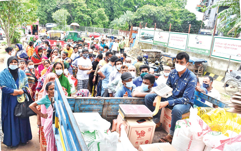 People gather in front of a TCB truck to buy daily essentials amid 