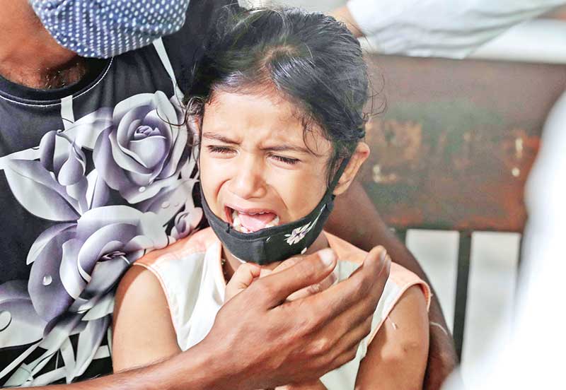 A kid shows the picture of his mother as samples were taken for DNA tests at Dhaka Medical College Hospital on Saturday for identifying the charred bodies of the victims of the devastating fire at Hashem Foods factory in Rupganj upazila of Narayanganj. 	PHOTO: OBSERVER