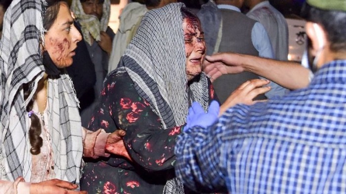 Wounded women arrive at a hospital for treatment after two blasts outside the airport in Kabul. [AFP]