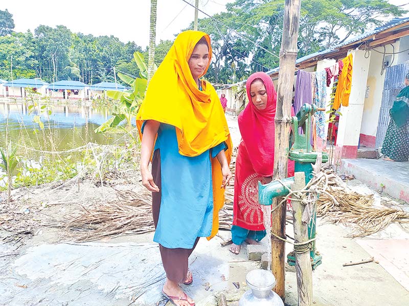 Two young ladies collecting drinking water from a tubewell at Char Nizam.	photo: observer