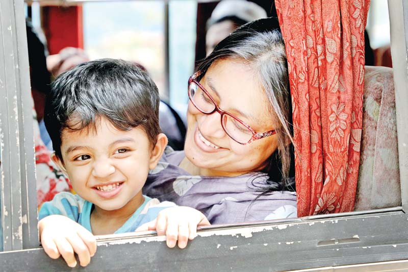 A grinning child with her smiling mother waiting for the bus to leave Gabtoli bus terminal in the capital on Thursday on their journey home to celebrate Eid-ul-Azha.	PHOTO: OBSERVER