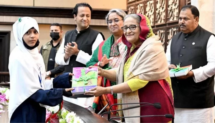 Prime Minister Sheikh Hasina handing over free textbooks to students of primary and secondary levels at a function at the Prime Minister’s Office (PMO) on Saturday morning — BSS Photo