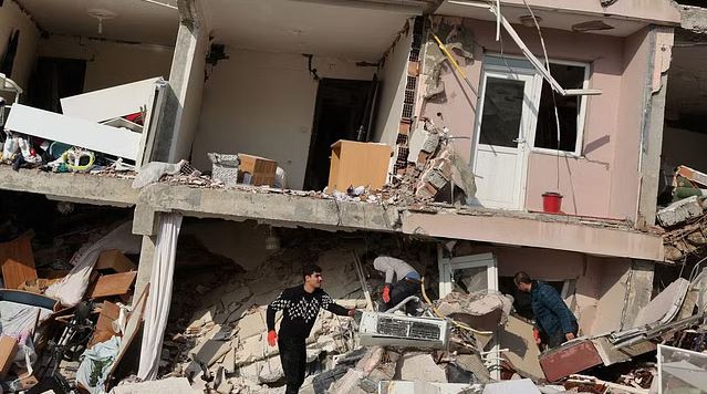 People look amid rubble as the search for survivors continues following an earthquake in Hatay, Turkey.