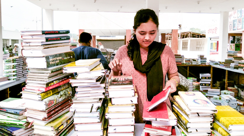 A young girl seen on Friday preparing her book stall for the month-long journey by organizing books to make attractive the stall. Photo: Sumit Ahmed