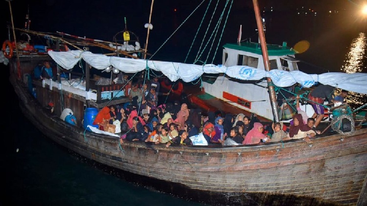 Rohingya refugees sit in a wooden boat as it arrives at Krueng Geukueh Port in North Aceh, Indonesia, Thursday, Dec. 30, 2021. An Indonesian navy ship towed the boat carrying 120 Rohingya Muslims into the port after it had drifted for days off the country's northernmost province of Aceh, a navy official said. PHOTO: AP