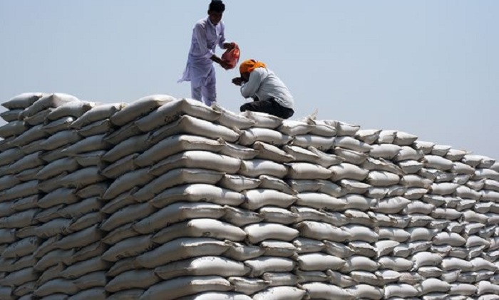 Workers drink water while stacking up wheat sacks at the grain market in May. PHOTO: Bloomberg