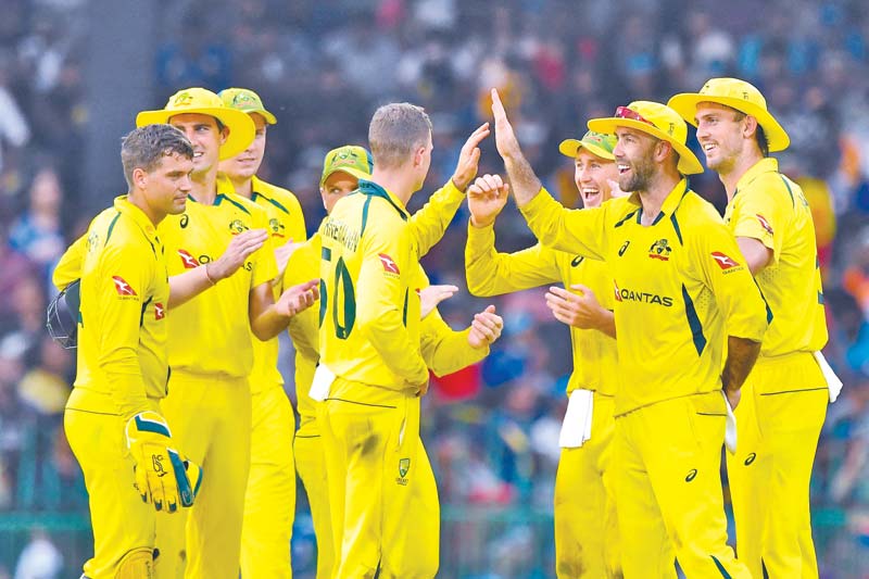 Australia's Matthew Kuhnemann (L) celebrates with teammates after taking the wicket of Sri Lanka's Chamika Karunaratne (not pictured) during the fourth one-day international (ODI) cricket match between Sri Lanka and Australia at the R. Premadasa International Cricket Stadium in Colombo on June 21, 2022.