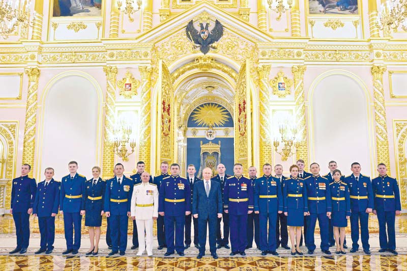 Russian President Vladimir Putin (C) poses for a photo with graduates