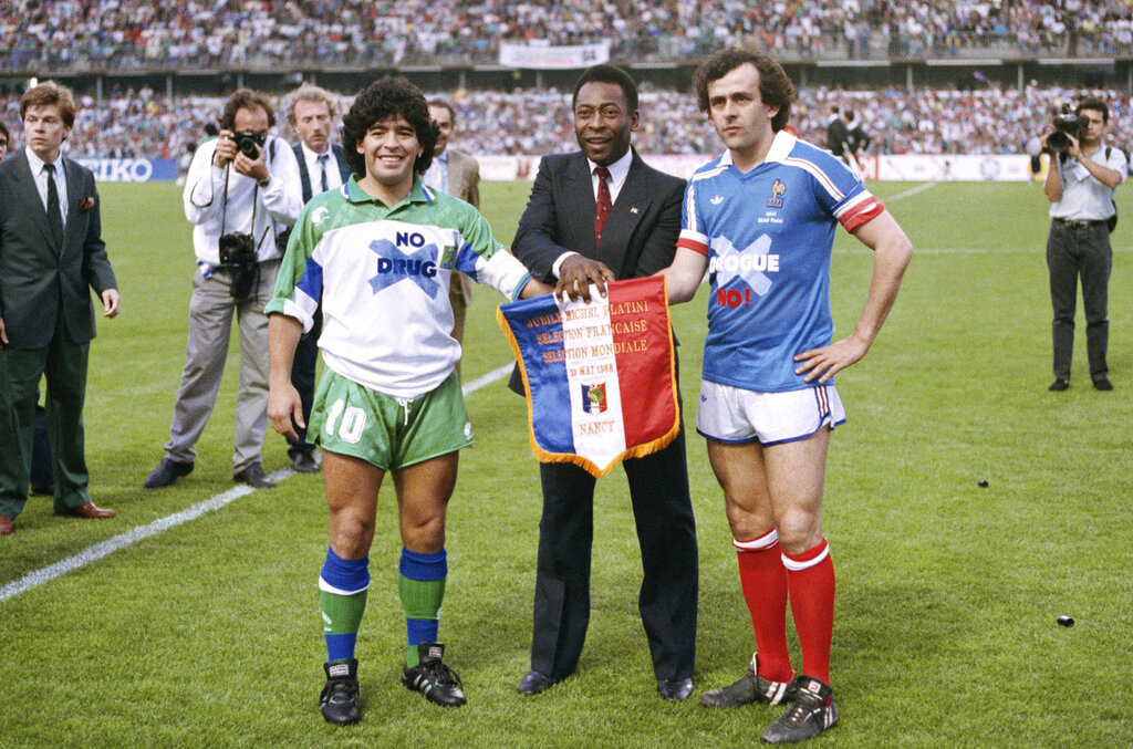 In this May 23, 1998 file photo, soccer stars Argentina's Diego Maradona, left, Pele of Brazil, center, and France's Michel Platini pose shaking hands during Platini's jubilee at Nancy stadium, eastern France. Former France great Michel Platini, one of Diego Maradona's fiercest rivals when they both played in the Italian league during the 1980's, said the late Argentine soccer star was "the greatest football lover there was." Maradona died on Wednesday from a heart attack, aged 60