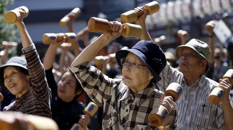 Elderly and middle-aged people exercise with wooden dumbbells during a health promotion event to mark Japan's Respect for the Aged Day at a temple in Tokyo's Sugamo district, an area popular among the Japanese elderly, September 21, 2015. Photo: Reuters