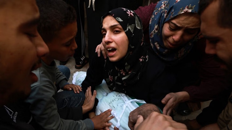 A woman reacts as she holds the body of her baby girl killed in an Israeli strike in Rafah in the southern Gaza Strip, in the courtyard of the al-Najjar hospital on Friday.