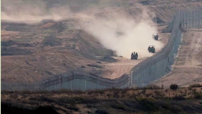 Military vehicles manoeuvre next to a fence, as seen from the Israeli side of the border with Gaza, November 5, 2023. REUTERS/Ronen Zvulun/File Photo 